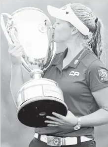  ?? JONATHAN HAYWARD
THE CANADIAN PRESS ?? Brooke Henderson, 20, of Smiths Falls, Ont., kisses the trophy after winning the CP Women’s Open in Regina on Sunday.