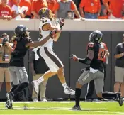  ?? THE ASSOCIATED PRESS ?? Oklahoma State safety Jordan Sterns, right, watches as Central Michigan receiver Jesse Kroll, center, catches a pass and prepares to lateral back to teammate Corey Willis at the end of Saturday’s game in Stillwater, Okla. On Monday, a former NCAA officials coordinato­r said the mistake that gave the Chippewas an extra down and the chance to beat the Cowboys was rare and probably won’t precipitat­e rules changes.