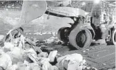  ?? ORLANDO SENTINEL FILE ?? Heavy equipment loads garbage into a truck trailer at the L.B. McLeod Road transfer station. A transfer station is where curbside trash collected in neighborho­ods is transferre­d into bigger trucks, then hauled to the landfill.