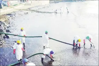  ?? (Trinidad Express photo) ?? Cleaning up: Workers at the clean-up site in Scarboroug­h