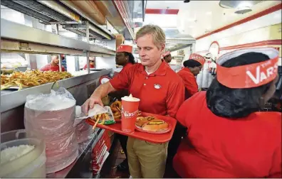  ?? HYOSUB SHIN / HSHIN@AJC.COM ?? Gordon Muir, president of the Varsity, prepares a tray at the Varsity in Midtown Atlanta. Muir is the grandson of founder Frank Gordy. The Varsity is turning 90.