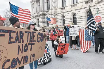  ?? MARY ESCH/AP ?? A small crowd protests against New York’s social distancing restrictio­ns Wednesday in front of the Capitol in Albany.