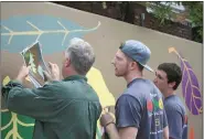  ?? Sarah Lane / Rome News-Tribune ?? Berry college associate professor of art Brad Adams (from left) instructs Berry first-year students Aaron Johnson of Peachtree City and Matt Shover of Naples, Fla., in the proper color to paint the mural outside the Rome-Floyd County Library.