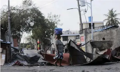  ?? Photograph: Ralph Tedy Erol/Reuters ?? A woman walks past a barricade amid gang violence in Port-au-Prince, Haiti.