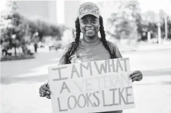  ?? Elizabeth Conley / Houston Chronicle ?? Army veteran Christy Chatham lets her sign do the talking before she marched to City Hall with other female veterans Saturday to celebrate progress and speak out against abuse and challenges they face.