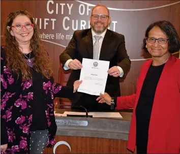  ?? SOUTHWEST BOOSTER PHOTO ?? Tekeyla Friday from the Swift Current Branch Library and Southwest Literacy Committee member Bula Ghosh assist Mayor Denis Perrault in proclaimin­g the week of January 26 to February 1 as Family Literacy Week in the City of Swift Current.