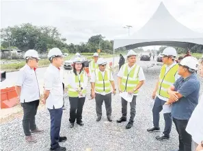  ?? ?? TURUN PADANG: Aidel bersama Fazzrudin ketika meninjau tapak projek naik taraf Jalan Matang Baru Fasa Dua semalam.