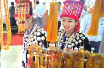  ??  ?? Kachin women viewing amber necklaces and bracelets during the annual gems and jewellery exposition in Naypyidaw. — AFP photos