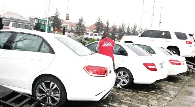  ?? Photo: EFCC ?? Operatives of the Economic and Financial Crimes Commission raid an automobile shop in Lagos yesterday, where 29 exotic cars were impounded. The commission alleged that the shop operators were a syndicate of organized Internet fraudsters. See story on page 5 &gt;&gt;&gt;