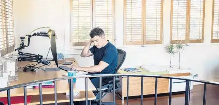  ?? JESSICA CHOU/THE NEW YORK TIMES ?? Brian Chesky, CEO of Airbnb, working at his home June 8 in San Francisco. The company laid off a quarter of its workforce this year.