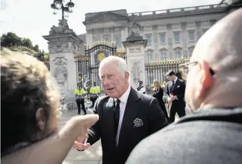  ?? CHRISTOPHE ENA AP ?? King Charles III greets mourners Friday outside Buckingham Palace in London. Queen Elizabeth II, Britain's longest-reigning monarch and a rock of stability across much of a turbulent century, died Thursday.