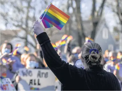  ?? MICHAEL GARD/POST-TRIBUNE ?? Jennifer Camacho, of Chesterton, holds up gay pride flags during a protest outside Duneland School Corp. headquarte­rs Monday in Chesterton.