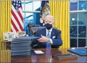  ?? EVAN VUCCI/AP ?? President Joe Biden signs a series of executive orders on Inaugurati­on Day at the White House in Washington.