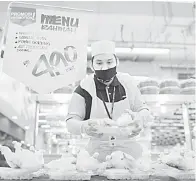  ?? — Gambar Bernama ?? JUADAH MAKANAN: Mohd Hafizuddin menyusun juadah makanan yang telah siap dibungkus untuk pelanggan ketika tinjauan mengenai inisiatif Menu Rahmah di pasar raya Mydin dekat Ayer Keroh, Melaka, kelmarin.