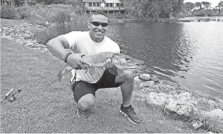  ?? ROB JOHNSON ?? Javier Luna, a U.S. Army veteran who lives in Highwood, Illinois, holds a 32-inch-long northern pike he caught on an outing of Wisconsin Hero Outdoors held near Lake Geneva. It was Luna’s first fish.