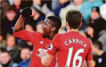  ?? Reuters ?? Manchester United’s Paul Pogba celebrates scoring the first goal against Swansea with Michael Carrick. United won 3-1 on Sunday thanks to a brace from Swede Zlatan Ibrahimovi­c too.