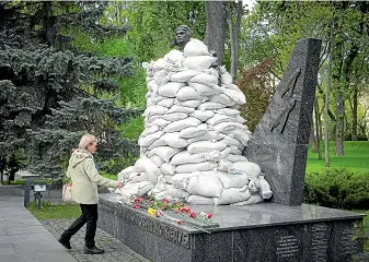  ?? AP ?? A woman lays flowers at the Tomb of the Unknown Soldier, protected by sandbags, in Kyiv yesterday. This year, Ukrainian leaders focused their World War II victory commemorat­ions on May 8, when western Europe celebrates VE Day, rather than the May 9 date venerated by Russia and former Soviet bloc countries.