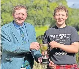  ?? ?? Congratula­tions
Society chair Arthur Lawrence presents Jules Ramsay with the Stewart Cup for Best Overall U18 Heavyweigh­t