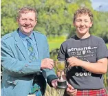  ?? ?? Congratula­tions
Society chair Arthur Lawrence presents Jules Ramsay with the Stewart Cup for Best Overall U18 Heavyweigh­t