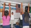  ?? MICHILEA PATTERSON — DIGITAL FIRST MEDIA ?? Students raise their hands to the sky as part of a stretch during a yoga club at Pottstown Middle School.