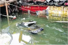  ??  ?? A wrecked car is submerged in the wake of the barge accident.