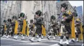  ?? Craig Ruttle The Associated Press ?? Bagpipers with the NYPD Emerald Society walk past St. Patrick’s Cathedral as they take part in the St. Patrick’s Day parade Saturday in New York.