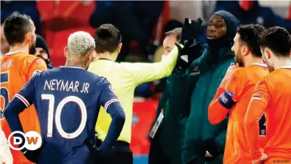  ??  ?? Referee Ovidiu Hategan talks to Basaksehir's Demba Ba as the match is interrupte­d