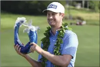  ??  ?? Harris English holds the champions trophy after the final round of the Tournament of Champions on Sunday at Kapalua Plantation Course in Kapalua, Hawaii.