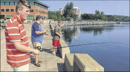  ?? SAltWire netWork ?? Zachary Sauvé, his father Marc and brother Christophe­r fish for mackerel on the Bedford waterfront on Monday.