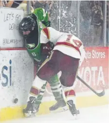  ?? Seth McConnell, Special to The Post ?? DU’s Jarid Lukosevici­us takes North Dakota’s Colton Poolman hard into the boards Friday night.