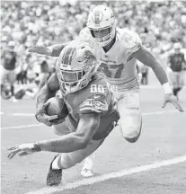  ?? JIM RASSOL/SUN SENTINEL ?? Detroit Lions tight end Michael Roberts scores a touchdown in the third quarter past Miami Dolphins linebacker Kiko Alonso.