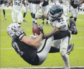  ?? Rick Scuteri Associated Press ?? RAIDERS tight end Foster Moreau hangs on for a touchdown catch despite the efforts of the Eagles’ Marcus Epps. Moreau started for the injured Darren Waller.