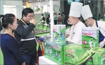  ?? WANG ZHUANGFEI / CHINA DAILY ?? A visitor tastes a milkshake at the booth of Fonterra, a global dairy exporter and manufactur­er from New Zealand, at the CIIE in Shanghai on Wednesday.