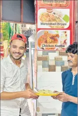  ??  ?? Eatery owner Muhammed Salman (left), in Mehrauli, holding a plate of fresh Moradabadi biryani, with cook Aalam Bhai.