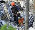  ?? FOTO: DPA ?? Ein Feuerwehrm­ann mit Spürhund in den Trümmern.