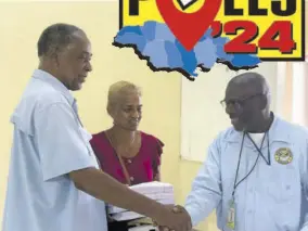  ?? ?? Lawton Mckenzie (left) who is contesting the Grange Hill Division as an independen­t candidate, is congratula­ted on his nomination by Electoral Office of Jamaica workers on Thursday.