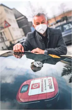  ?? FOTO: ANDREAS BRETZ ?? Rhein-Taxi Geschäftsf­ührer Michael Mühlin zeigt einen der neuen Luftfilter, die auf die Hutablage montiert werden.