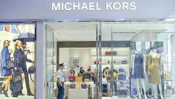  ??  ?? The newly renovated Michael Kors flagship store in Makati gets an upgrade with its play on metal accents seen on shelves and fixtures.