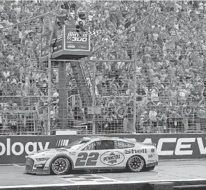  ?? JEFF ROBERSON/ AP ?? Joey Logano takes the checkered flag for a second time in 2002, winning the NASCAR Cup Series race at World Wide Technology Raceway.