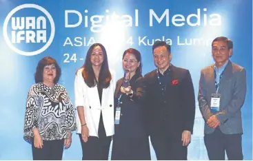  ?? — azlina abdullah/the star ?? All smiles: Wang (centre) flanked by Wee (left) and abdul sani posing for the camera after receiving the silver award trophy for the ‘Best use of ai in revenue strategy’ category. With them are Wan-ifra asia director Kah-whye lee (right) and Bisnis indonesia president director lulu Terianto who presented the award.