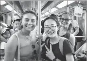  ?? ZHENG YAJING / FOR CHINA DAILY ?? Catalina Carrion Sierra (left) from King’s College London and Agne Bendaravic­iute (right) from Bournemout­h University take a subway to the Bund during their visit in Shanghai, accompanie­d by volunteer Peng Shasha (middle) from East China Normal University.