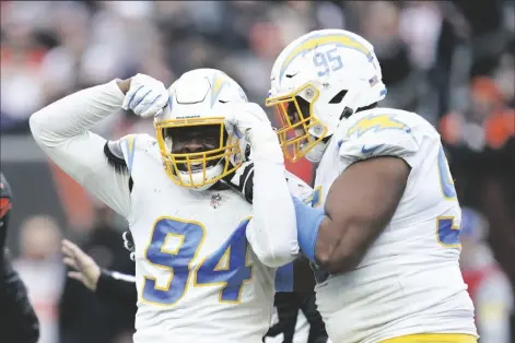  ?? MICHAEL CONROY/AP ?? LOS ANGELES CHARGERS’ CHRIS RUMPH II (94) and Christian Covington (95) celebrate a play during the second half of a game against the Cincinnati Bengals Sunday in Cincinnati.