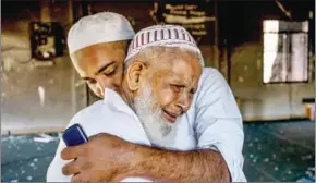  ?? ADAM DEAN/THE NEW YORK TIMES ?? An imam consoles a visitor as he looks around the burned-out mosque that was attacked by a Buddhist mob, in Digana, Sri Lanka, on March 11.