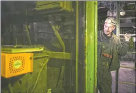  ??  ?? A Bosnian coal miner checks equipment in an undergroun­d tunnel.