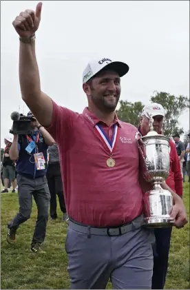  ?? Ap ?? Jon rahm leaves the 18th green with the champion's trophy after the final round of the U.s. open on sunday at torrey pines golf course in san diego.