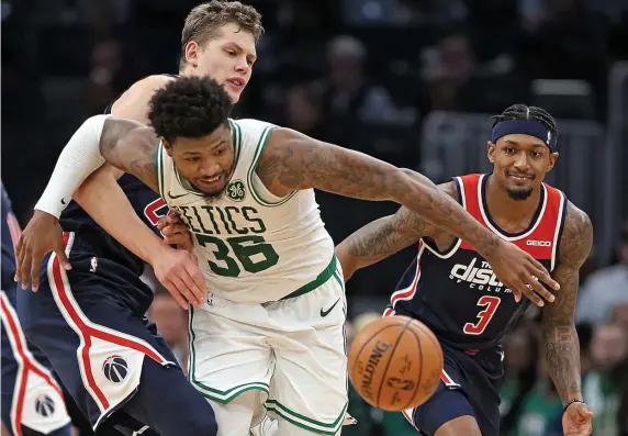  ?? MATT STONE / BOSTON HERALD ?? ALWAYS HUSTLING: Marcus Smart goes for a loose ball in front of Washington’s Moritz Wagner during the Celtics’ 140-133 win on Wednesday.