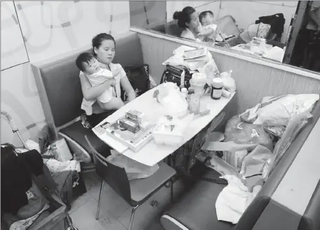  ?? XU XIAOFAN / FOR CHINA DAILY ?? Jiang Danli and her 9-month-old daughter have been staying in a 24-hour KFC store in Beijing’s Chaoyang district for nearly two months.