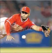  ?? Danny Moloshok Assocaited Press ?? SECOND BASEMAN Gregorio Petit dives to catch a ball thrown by catcher Carlos Perez, who was recalled from triple-A to take Geovany Soto’s roster spot.