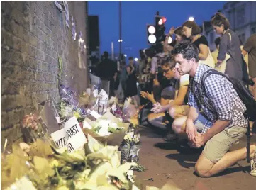  ??  ?? A man looks at messages and tributes left near the scene of the incident. — Reuters photo