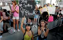  ?? PHOTO: AP ?? Marylene Dinliana, 18, holds a placard during a protest against guns on the steps of the Broward County Federal courthouse in Fort Lauderdale, Florida.